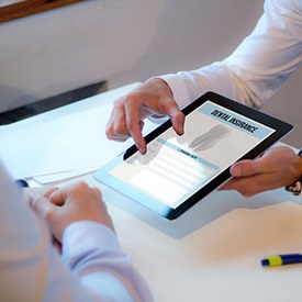 Patient reviewing dental insurance forms on tablet