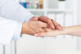 A dentist shaking hands with a patient