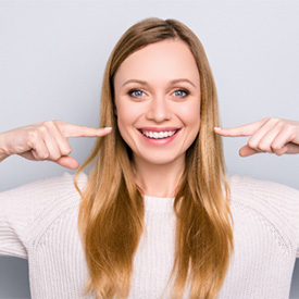 woman pointing to her smile