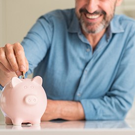 Patient saving money for cosmetic dentistry in Arnold via piggy bank 