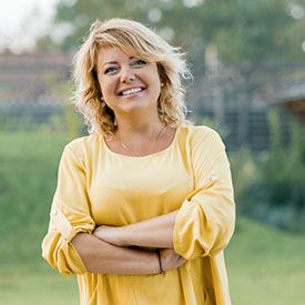 Woman smiling in yellow shirt while standing outside