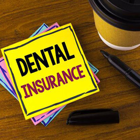 Dental insurance written on yellow note paper