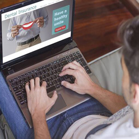 Man looking at dental insurance on computer