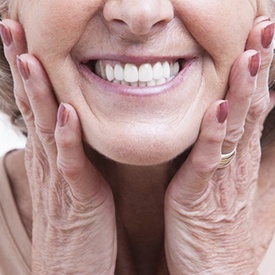 close up woman holding her face with dentures in Arnold 
