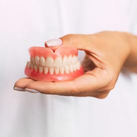 dentist holding pair of full dentures 