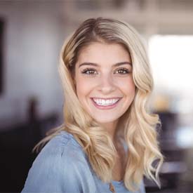 woman smiling after seeing emergency dentist in Arnold