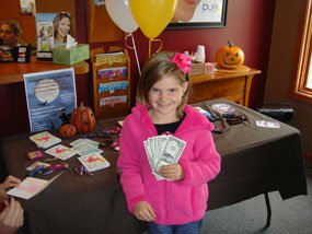 Child holding money after winning reward