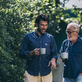 Two men having a conversation and coffee on their walk 