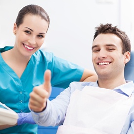 Man in dental chair giving thumbs up