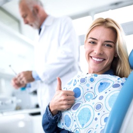 woman giving thumbs up in dental chair 