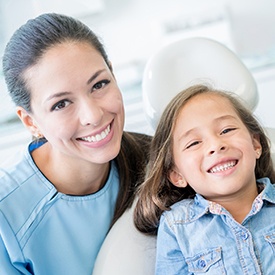 Smiling child and dental assistant in exam room