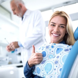 woman giving thumbs up in dental chair