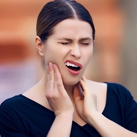 Woman in pain holding jaw