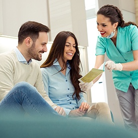 Couple smiling while reviewing cost of veneers in Arnold