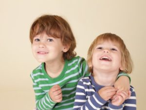 two young boys hugging and laughing