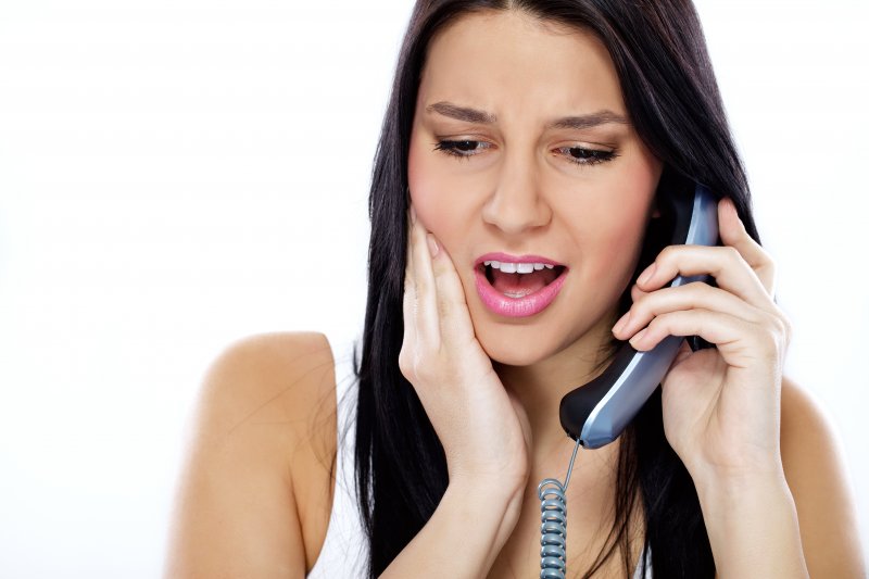woman calling dentist because of painful toothache